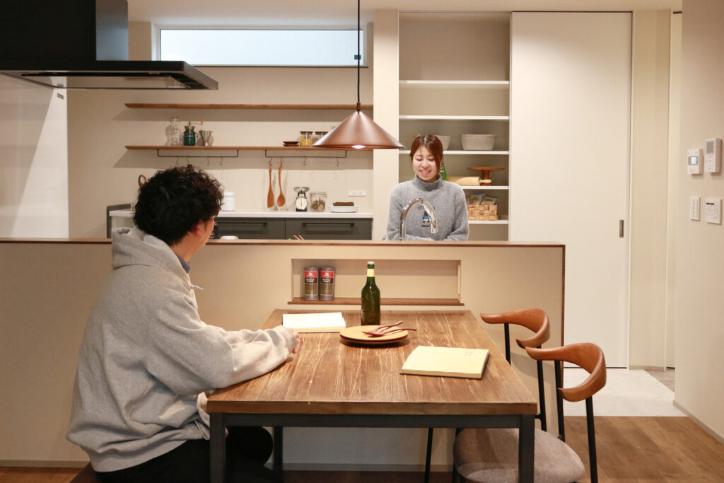 対面キッチンと一体感のある造作ダイニングテーブルで、家族が会話を楽しみながら過ごす温かみのあるLDK空間。
