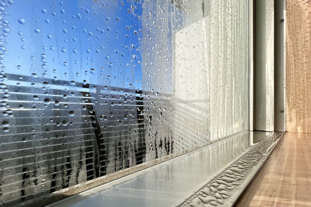冬の朝、アルミ樹脂複合サッシの枠やガラスにびっしりと付着し、サッシの下枠に溜まった激しい結露。