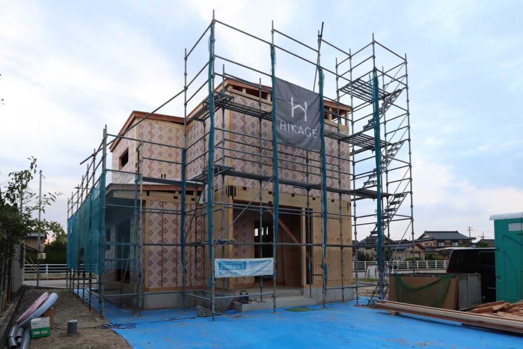 足場が組まれ、外壁に断熱材のネオマフォームが施工された木造住宅の建築現場外観。