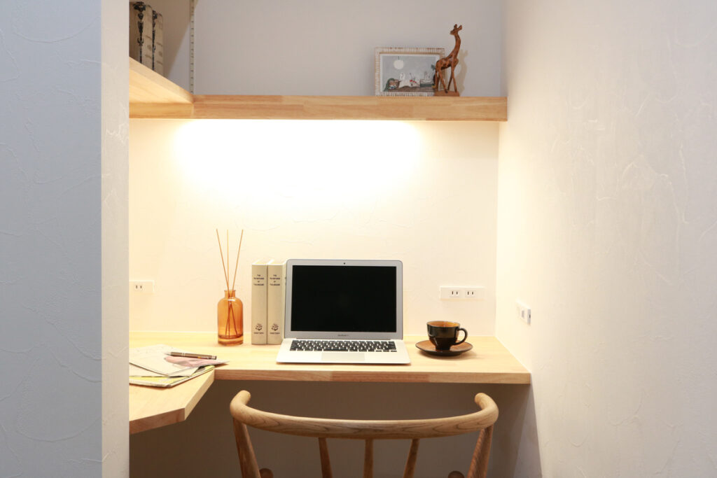 漆喰壁の質感と木の温もりが心地よい、L字型のカウンターと棚を設けた集中できるコンパクトな書斎コーナー。
