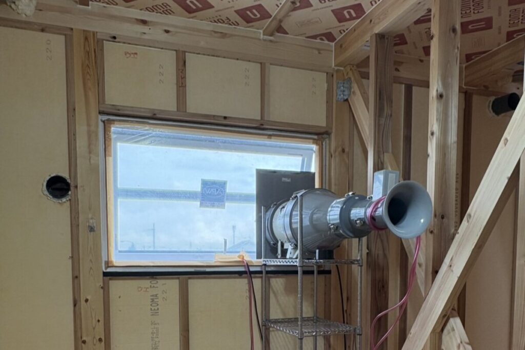 住宅の気密性能を数値化するために、窓の一部に専用の送風機を設置して行われている気密測定(C値測定)の様子。