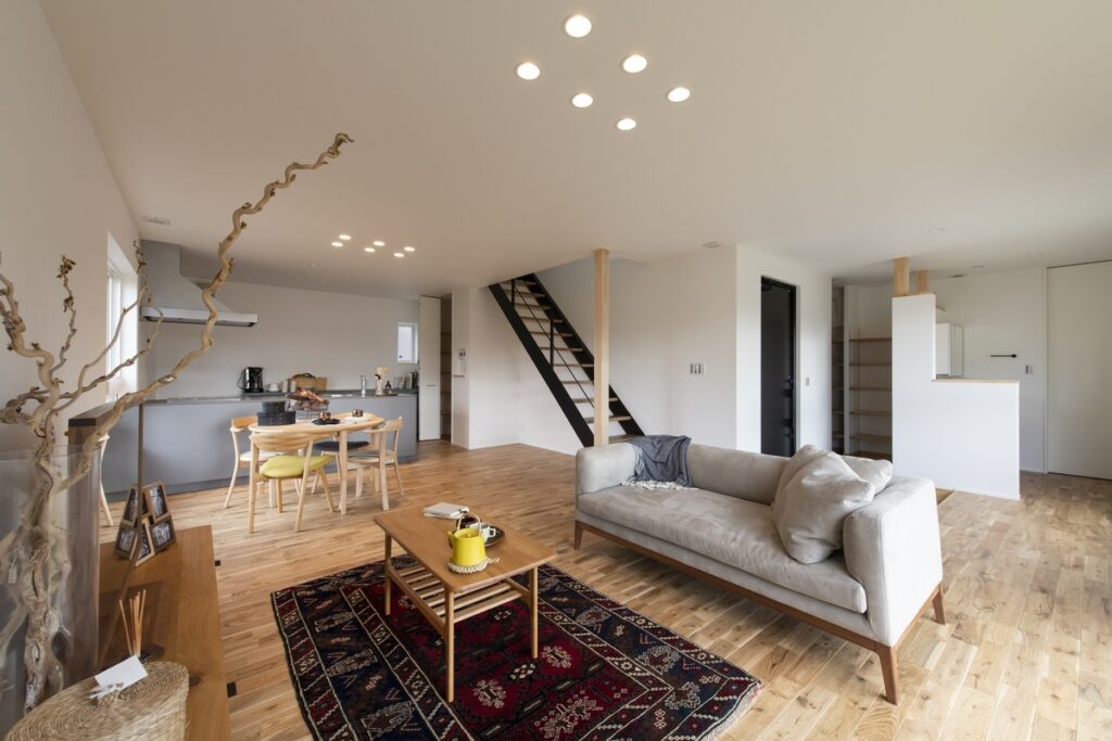 アクセントクロスとダークトーンの床材を組み合わせた、造作デスクと本棚が機能的な落ち着きのある寝室。