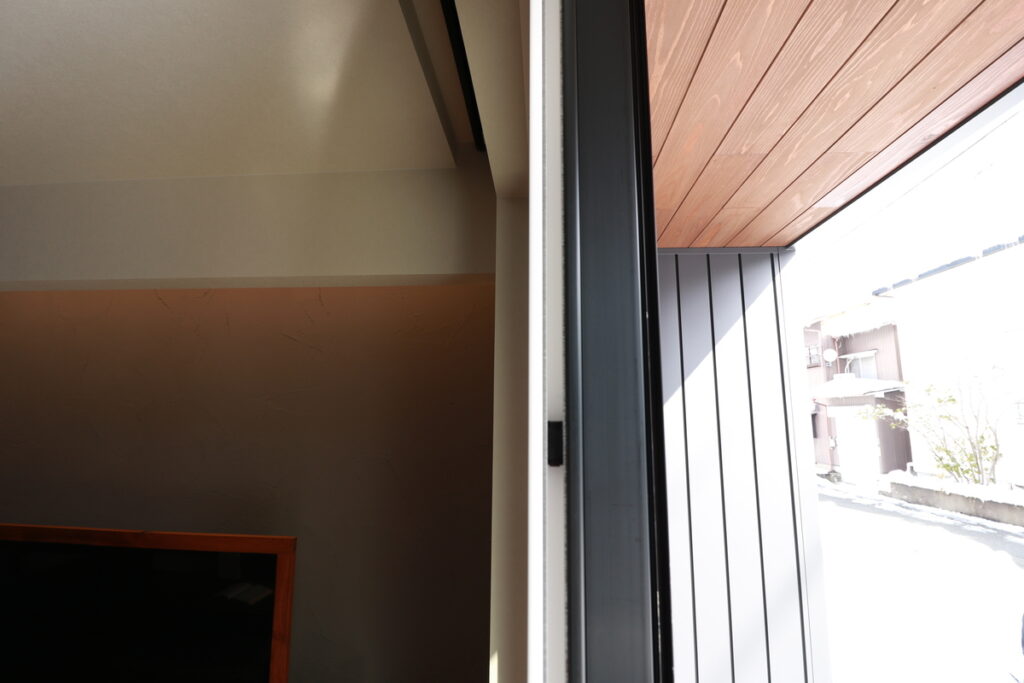 住宅の気密性能を確保するために、サッシ枠と構造体の隙間に丁寧に充填された発泡ウレタン断熱材の施工箇所。